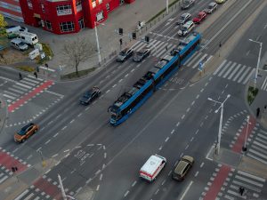 Aerial shot of a busy intersection in Wrocław, Poland, featuring cars and a tram.